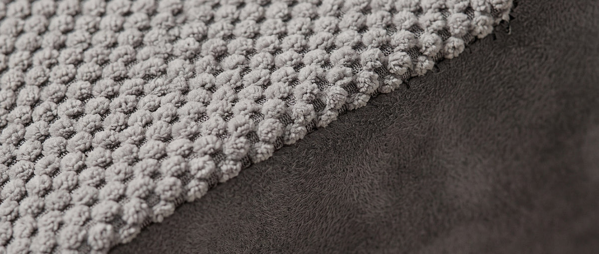 Close view of the grey popcorn knit tread meeting the charcoal microsuede on the Doxie Guard pet stairs