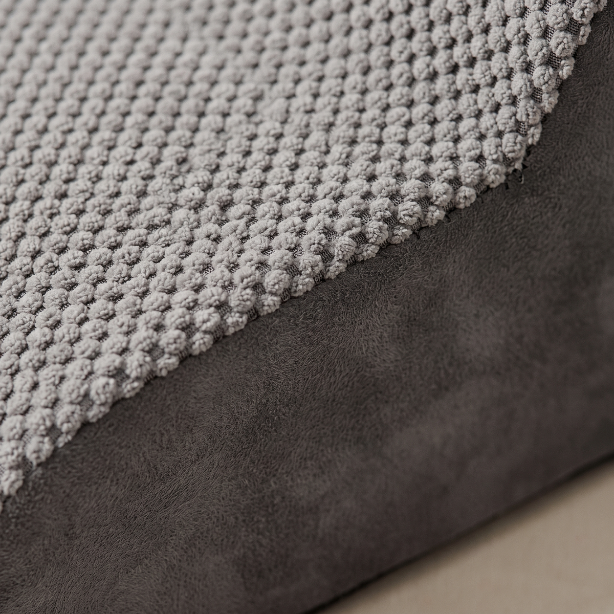 Close up of the grey popcorn knit tread meeting the charcoal microsuede side panel